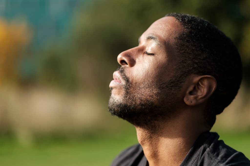Serene man breathing fresh air in nature, enjoying peace and tranquility